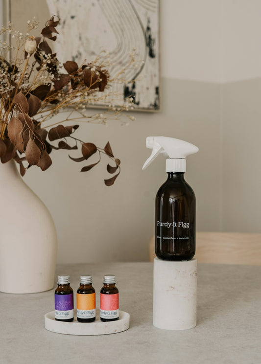 A bottle of spray sits on a table next to three bottles