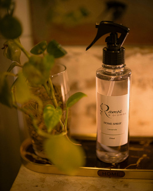 Clear home spray bottle next to a potted green plant.