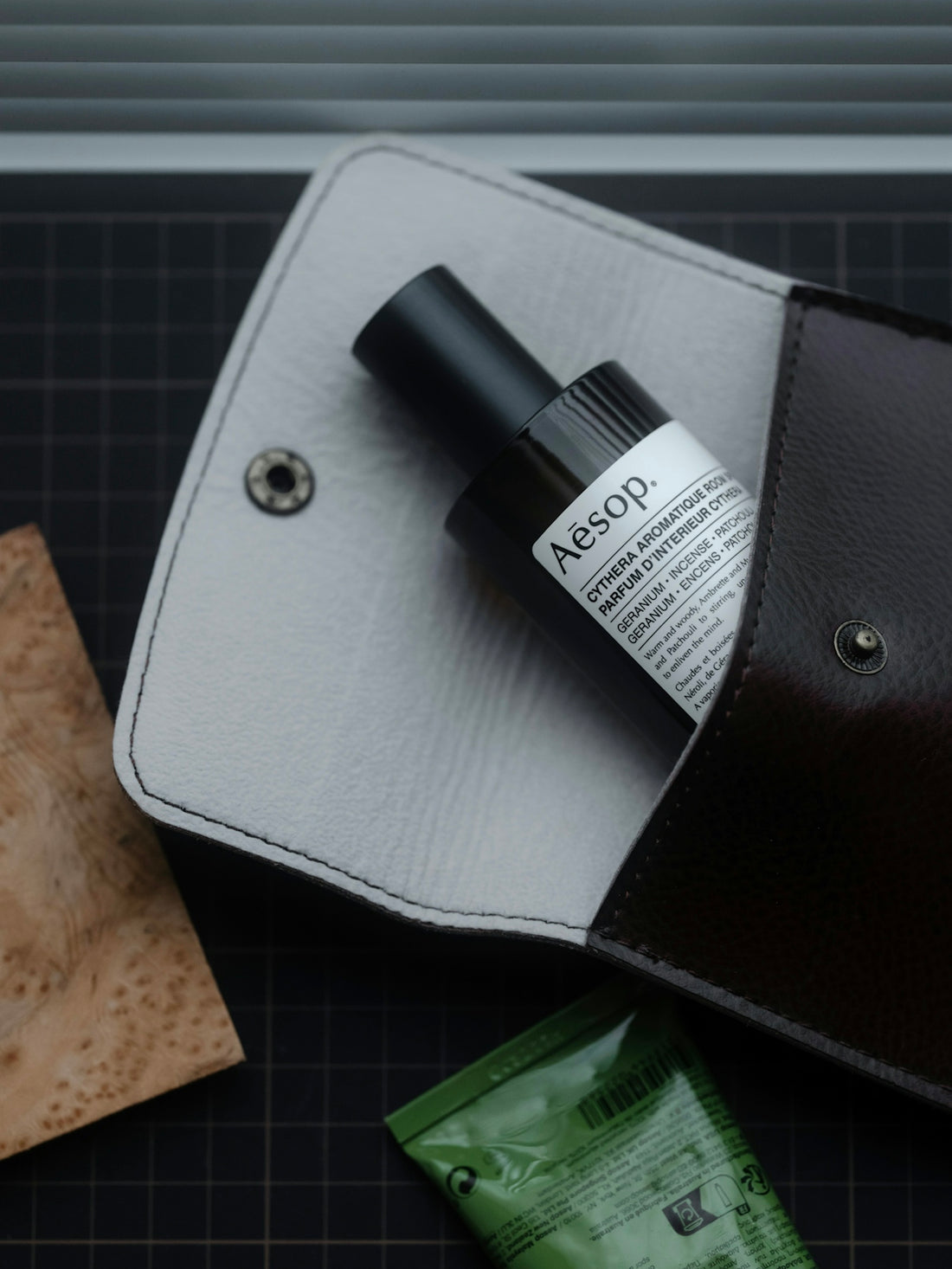 Aesop bottle inside a leather pouch with other items