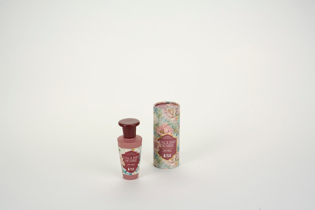 A room spray bottle and its floral patterned cylindrical box on a white surface